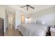 Neutral bedroom features a tray ceiling, wood floors, and connects to the bathroom at 8907 White Sage Loop, Lakewood Ranch, FL 34202