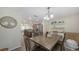 Open dining area connected to kitchen, features wood table, chandelier, and convenient bar with wine storage at 8907 White Sage Loop, Lakewood Ranch, FL 34202