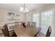 Bright dining area featuring a wood table, stylish chandelier, and convenient bar area for entertaining at 8907 White Sage Loop, Lakewood Ranch, FL 34202