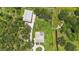 Aerial view of home with a long driveway, detached garage, and a creek in the backyard at 920 Lena Ln, Sarasota, FL 34240