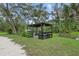 Outdoor kitchen with sink and grill, surrounded by mature trees and lush greenery at 920 Lena Ln, Sarasota, FL 34240
