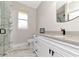 Modern bathroom featuring a marble tiled shower, white vanity and fixtures with black hardware at 920 Lena Ln, Sarasota, FL 34240
