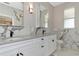 Gorgeous bathroom with double sinks, white cabinets, granite countertops and modern fixtures at 920 Lena Ln, Sarasota, FL 34240