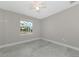 Neutral bedroom with light grey walls, white trim, ceiling fan and porcelain tiled floor at 920 Lena Ln, Sarasota, FL 34240