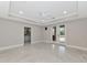 Bright main bedroom with tile flooring, a tray ceiling, patio access, and an ensuite bathroom at 920 Lena Ln, Sarasota, FL 34240