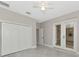 Neutral bedroom featuring light grey walls, ceiling fan, closet, and porcelain tiled floor at 920 Lena Ln, Sarasota, FL 34240