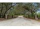 Gated entrance to a property with a tree lined driveway at 920 Lena Ln, Sarasota, FL 34240