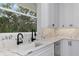 Kitchen sink and counter with marble countertops, modern faucet, stainless steel appliances, and a backyard view at 920 Lena Ln, Sarasota, FL 34240