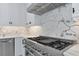 Professional grade stainless steel range with six burners, stainless vent hood and modern marble backsplash at 920 Lena Ln, Sarasota, FL 34240