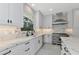 Well-lit kitchen featuring white cabinets, marble countertops and backsplash, stainless steel appliances, and a view of the outdoors at 920 Lena Ln, Sarasota, FL 34240