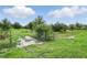 A gated entrance leads to open land, with a tranquil pond, set beneath a partly cloudy sky at 920 Lena Ln, Sarasota, FL 34240