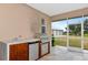 Outdoor kitchen featuring a gas grill, mini refrigerator, and prep area on a screened patio at 920 Lena Ln, Sarasota, FL 34240