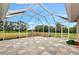 Spacious screened-in patio featuring tile flooring and a view of the backyard and surrounding landscape at 920 Lena Ln, Sarasota, FL 34240