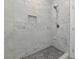 Tiled shower with mosaic flooring and a convenient inset shelf for toiletries and showering accessories at 920 Lena Ln, Sarasota, FL 34240