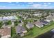 Expansive aerial view of a neighborhood featuring a tranquil lake surrounded by lush greenery and well-kept homes at 9927 58Th E St, Parrish, FL 34219