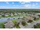 Scenic aerial view of a neighborhood with a central lake, lush trees, and well-spaced homes at 9927 58Th E St, Parrish, FL 34219