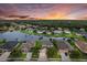 Stunning sunset aerial view of a community with a lake, lush greenery, and beautifully designed homes at 9927 58Th E St, Parrish, FL 34219