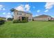 Expansive backyard featuring a lush lawn, tropical plants, and a screened lanai for outdoor living at 9927 58Th E St, Parrish, FL 34219