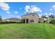 A spacious backyard with lush grass, palm trees, and a screened-in porch, perfect for outdoor relaxation at 9927 58Th E St, Parrish, FL 34219