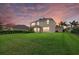 A spacious backyard with lush grass, palm trees, and a screened-in porch, perfect for outdoor relaxation at 9927 58Th E St, Parrish, FL 34219