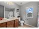 Well-lit bathroom featuring a vanity, toilet, and window with natural light at 9927 58Th E St, Parrish, FL 34219