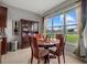 Cozy dining area with a round table and chairs, next to a large window overlooking the backyard at 9927 58Th E St, Parrish, FL 34219