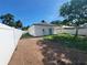 Backyard with newly laid dirt and grass features a white privacy fence and covered porch at 1019 34Th W Ave, Bradenton, FL 34205