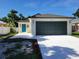 Inviting home featuring a two-car garage, a blue front door, and a well-maintained lawn at 1019 34Th W Ave, Bradenton, FL 34205