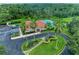 Aerial view showcasing a community pool and clubhouse surrounded by lush landscaping and palm trees at 12851 24Th Street E Cir, Parrish, FL 34219