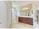 Well-lit bathroom with a glass-enclosed shower, double sink vanity, and neutral tile at 12851 24Th Street E Cir, Parrish, FL 34219