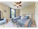 Comfortable bedroom with two twin beds, a ceiling fan, and a window with blue curtains at 12851 24Th Street E Cir, Parrish, FL 34219