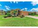 Lovely home with green grass, mature landscaping, and a decorative driveway at 12851 24Th Street E Cir, Parrish, FL 34219