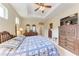 Relaxing bedroom with tray ceiling, craftsman dresser, and ceiling fan at 12851 24Th Street E Cir, Parrish, FL 34219