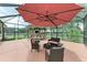 Relaxing outdoor lounge with an umbrella, a tiki bar, a table, and comfortable seating at 12851 24Th Street E Cir, Parrish, FL 34219