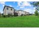 Wide backyard featuring a lush lawn, black fencing, and a view of neighboring homes and a serene sky at 16419 Paynes Mill Dr, Bradenton, FL 34211