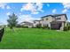 Expansive backyard with a lush lawn, black fence and view of other homes at 16419 Paynes Mill Dr, Bradenton, FL 34211