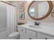 Bathroom featuring a white vanity with framed round mirror, and a shower with a white shower curtain at 16419 Paynes Mill Dr, Bradenton, FL 34211