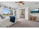Inviting bedroom with blue accents, a large window with neighborhood views, and a mounted TV at 16419 Paynes Mill Dr, Bradenton, FL 34211