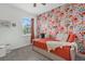 Cozy bedroom featuring vibrant floral wallpaper, a stylish daybed, and soft, inviting textiles and pillows at 16419 Paynes Mill Dr, Bradenton, FL 34211