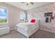 Bright bedroom featuring a patterned accent wall, plush carpet, and a window view with plenty of natural light at 16419 Paynes Mill Dr, Bradenton, FL 34211