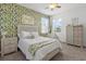 Charming bedroom with floral wallpaper, natural light, and white accents creates a calming and inviting space at 16419 Paynes Mill Dr, Bradenton, FL 34211