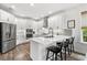 Contemporary white kitchen featuring stainless steel appliances, modern fixtures, and counter seating at 16419 Paynes Mill Dr, Bradenton, FL 34211