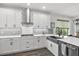 Bright kitchen featuring white cabinets, stainless steel appliances, gray subway tile backsplash, and a farmhouse sink at 16419 Paynes Mill Dr, Bradenton, FL 34211