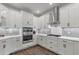 Bright kitchen with white cabinets, stainless steel appliances, gray subway tile backsplash and wood-look floors at 16419 Paynes Mill Dr, Bradenton, FL 34211