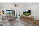 Comfortable living room with large windows, a view of the lake and a wall-mounted television at 16419 Paynes Mill Dr, Bradenton, FL 34211