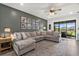 Open living room with a large sectional couch, shiplap accent wall, and sliding glass doors with a view at 16419 Paynes Mill Dr, Bradenton, FL 34211
