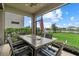 Relaxing screened patio with a dining table overlooking a serene lake view, perfect for outdoor entertaining at 16419 Paynes Mill Dr, Bradenton, FL 34211