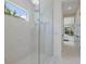 Bathroom featuring glass shower, white tiled walls, and an adjoining bedroom at 16511 Cornwall Ln, Lakewood Ranch, FL 34202