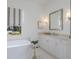 A bathroom with a white soaking tub, marble floors, vanity and designer fixtures at 16511 Cornwall Ln, Lakewood Ranch, FL 34202