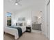 A bedroom adjacent to the bathroom with a large bed, a window and neutral colors at 16511 Cornwall Ln, Lakewood Ranch, FL 34202